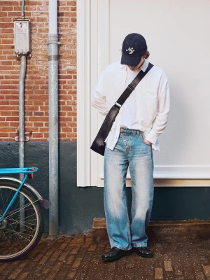 Bershka Jeansy O Kroju Barrel Z Krzyżującymi Się Guzikami Mężczyzna Wyblakły Niebieski