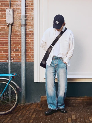 Bershka Jeansy O Kroju Barrel Z Krzyżującymi Się Guzikami Mężczyzna Wyblakły Niebieski