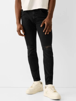 Bershka Jeansy O Kroju Skinny Z Efektem Podarcia Mężczyzna Czarny