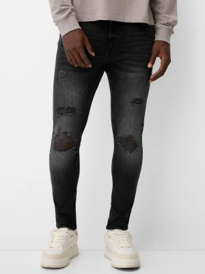 Bershka Jeansy O Kroju Super Skinny Z Efektem Podarcia Mężczyzna Czarny