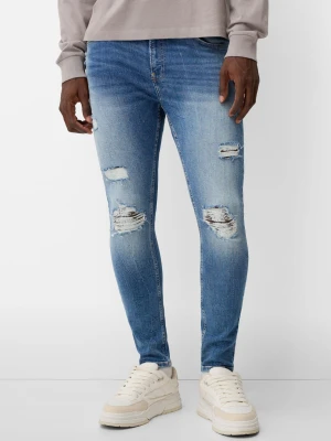 Bershka Jeansy O Kroju Super Skinny Z Efektem Podarcia Mężczyzna Niebieski