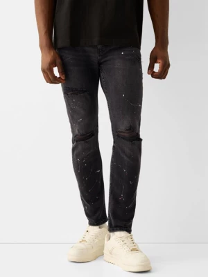 Bershka Jeansy Skinny Z Przetarciami I Plamami Farby Mężczyzna Szary