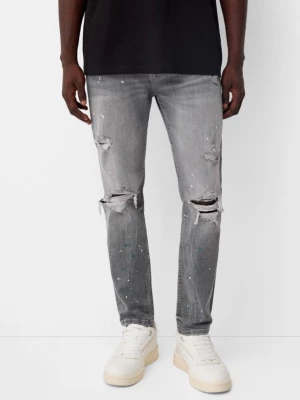 Bershka Jeansy Skinny Z Przetarciami I Plamami Farby Mężczyzna Szary