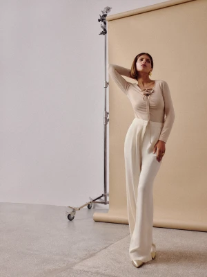 Beżowa bluzka z marszczeniem i ozdobnym kwiatem TARANKO