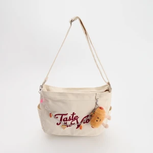 Beżowa torebka z haftem i brelokiem House