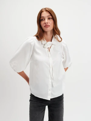 Biała bluzka z dekoracyjnym kwiatem Top Secret