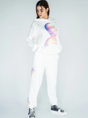 Białe spodnie dresowe z kolorowymi nadrukami na nogawkach Reporter