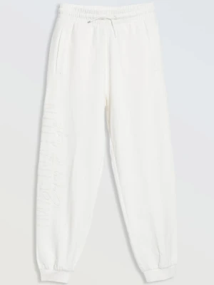 Białe spodnie dresowe z nadrukiem na nogawce Reporter