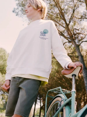 Zdjęcie produktu Bluza z bawełny z nadrukiem tekstowym złamana biel - Dzieci - lata - MANGO KIDS