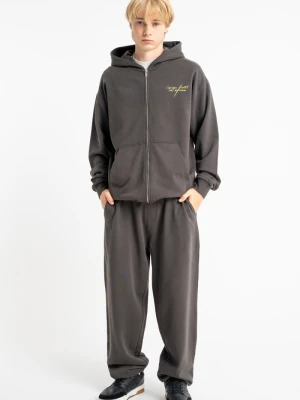 Spodnie chłopięce dresowe szerokie oversize z nadrukiem na nogawce Reporter