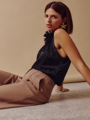 Czarna bluzka z dekoltem typu halter i kwiatem pod szyją TARANKO