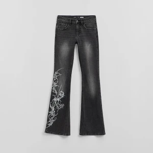 Czarne jeansy bootcut z niskim stanem i tribalowym nadrukiem na nogawce House