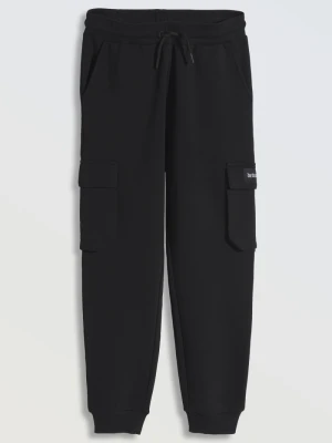 Czarne spodnie dresowe oversize z przestrzennymi kieszeniami na nogawkach Reporter