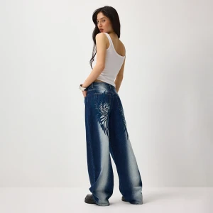 Granatowe jeansy wide leg z przetarciami i motywem skrzydeł House