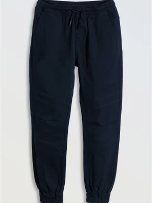 Granatowe spodnie typu joggery z modnymi przeszyciami Reporter