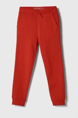 Guess spodnie dresowe bawełniane dziecięce kolor czerwony gładkie