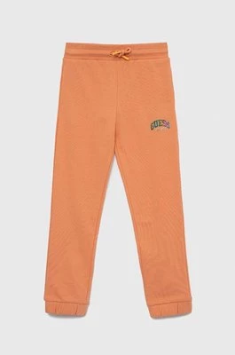 Guess spodnie dresowe bawełniane dziecięce kolor pomarańczowy gładkie