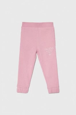 Guess spodnie dresowe bawełniane dziecięce kolor różowy z nadrukiem