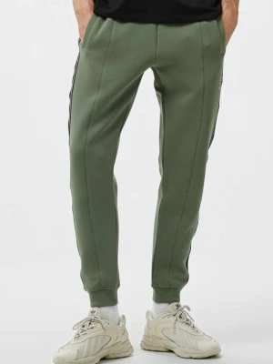 GUESS Zielone męskie spodnie dresowe z lampasami Mickey, Rozmiar XL