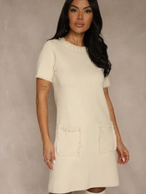 Jasnobeżowa Sweterkowa Sukienka Trapezowa z Perełkami przy Dekolcie i Kieszeniach Fenatusa