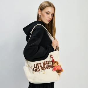 Kremowa torebka z haftem i brelokami House