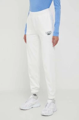 Lacoste spodnie dresowe kolor beżowy z nadrukiem