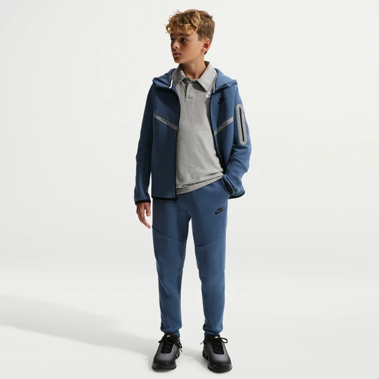 Zdjęcie produktu Joggery z akcentami o designie odbijającym światło dla dużych dzieci Nike Tech Fleece - Niebieski