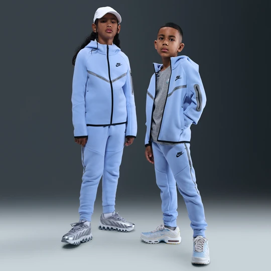 Zdjęcie produktu Joggery z akcentami o designie odbijającym światło dla dużych dzieci Nike Tech Fleece - Niebieski