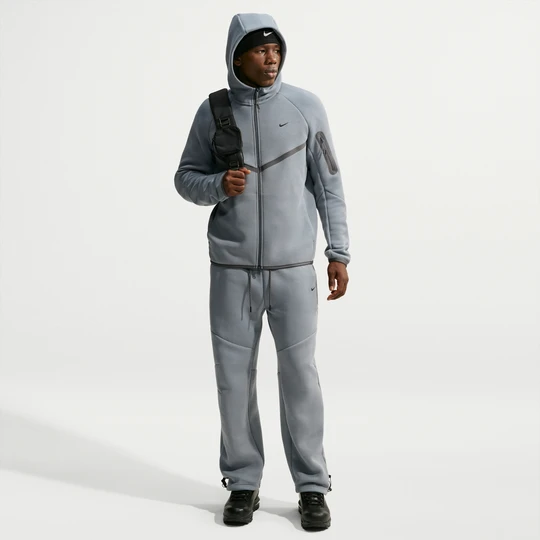 Zdjęcie produktu Męskie dzianinowe spodnie z luźnymi nogawkami i detalami o designie odbijającym światło Nike Tech - Szary