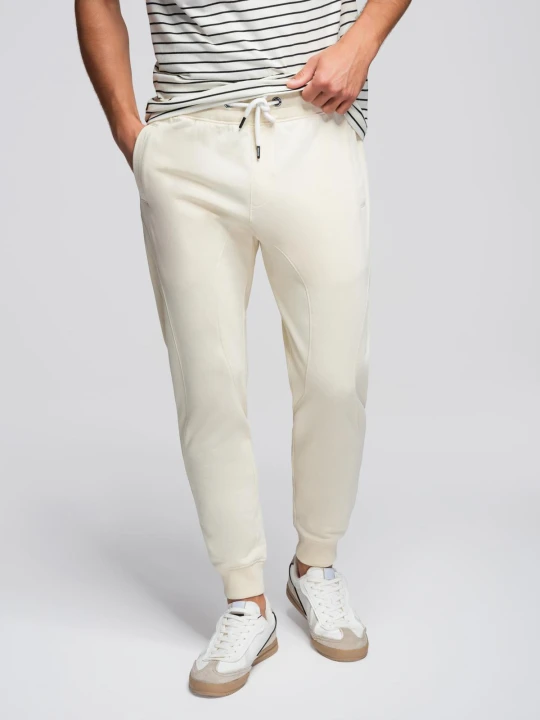 Zdjęcie produktu Męskie spodnie dresowe typu jogger - kremowe V11 - Rozmiar: XL Ombre Clothing kremowy