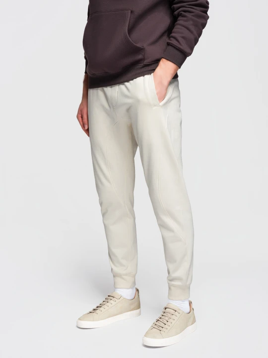 Zdjęcie produktu Męskie spodnie dresowe ze ściągaczem przy nogawce BASIC jogger - kremowe V11 - Rozmiar: L Ombre Clothing kremowy