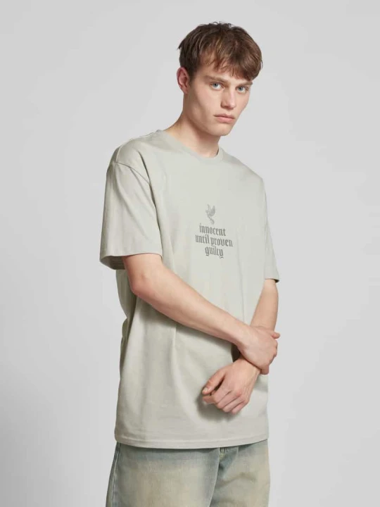 Zdjęcie produktu Oversize’owy T-shirt z nadrukiem z przesłaniem Mister Tee Jasnoszary