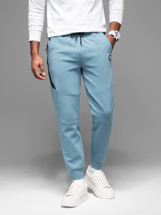 Zdjęcie produktu Spodnie dresowe męskie ze ściągaczami i ozdobnym zamkiem – jasnoniebieskie V4 - Rozmiar: XL Ombre Clothing