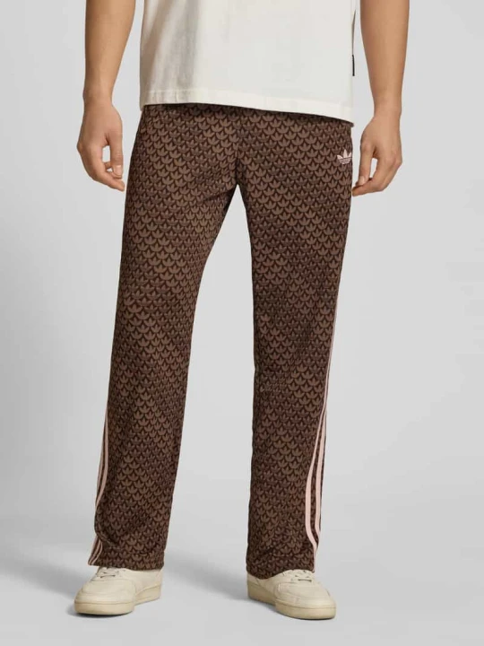 Zdjęcie produktu Spodnie dresowe o kroju loose fit z wzorem z logo model 'FIREBIRD' adidas Originals Ciemnobrązowy