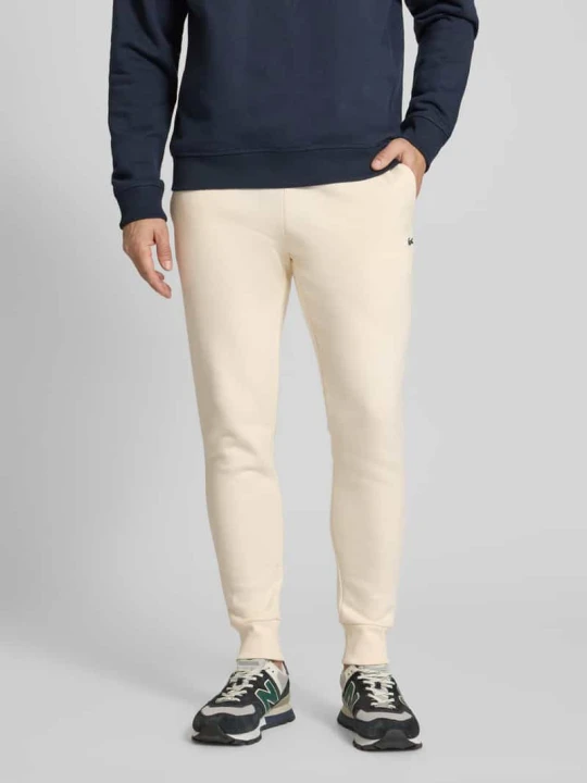 Zdjęcie produktu Spodnie dresowe o kroju regular fit z mieszanki bawełny Lacoste Złamany biały