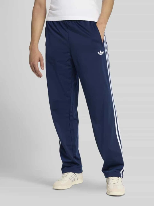 Zdjęcie produktu Spodnie dresowe o kroju regular fit z paskami w kontrastowym kolorze model 'FIREBIRD TP' adidas Originals