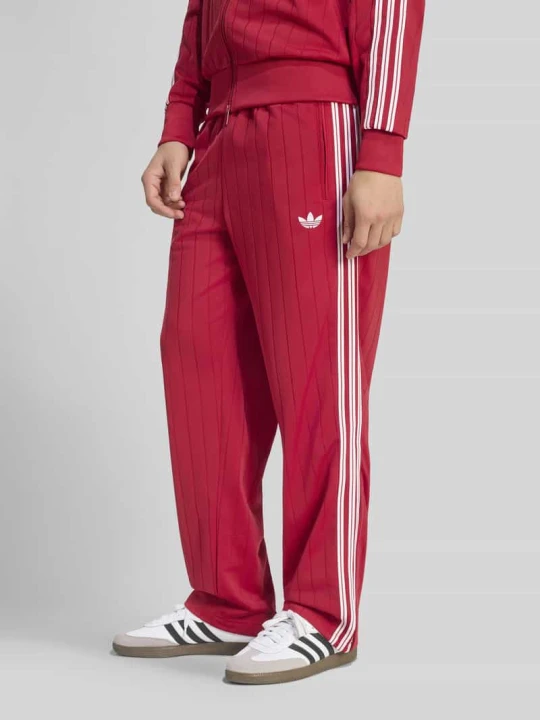Zdjęcie produktu Spodnie dresowe o kroju regular fit z paskami w kontrastowym kolorze model 'FIREBIRD TP DN' adidas Originals
