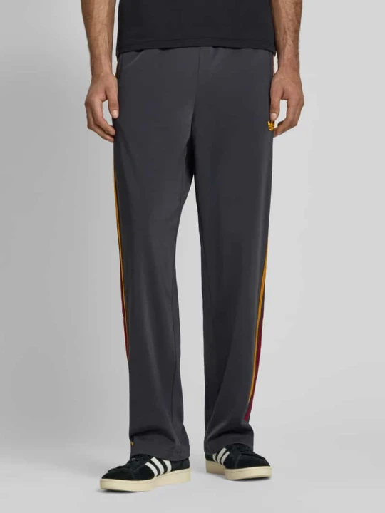 Zdjęcie produktu Spodnie dresowe o kroju relaxed fit z paskami z logo model 'FIREBIRD' adidas Originals Antracytowy