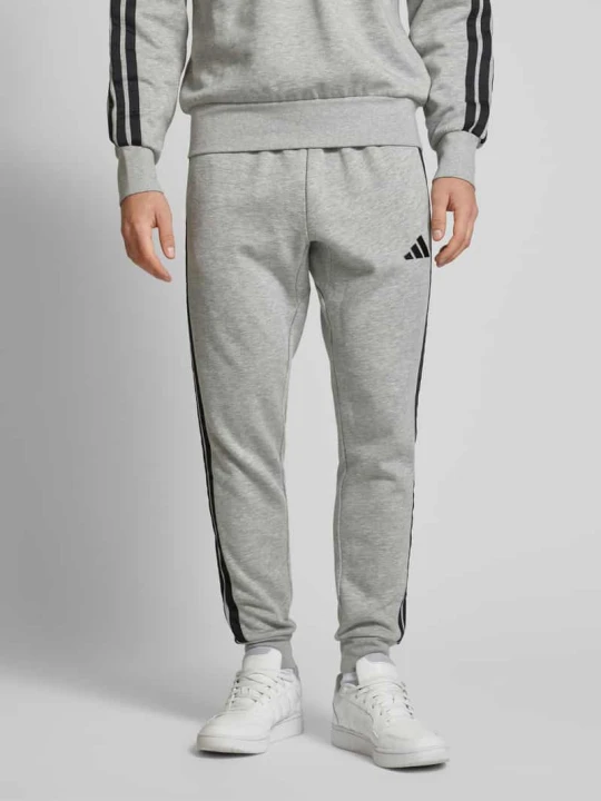 Zdjęcie produktu Spodnie dresowe o kroju relaxed fit z wyhaftowanym logo Adidas Jasnoszary