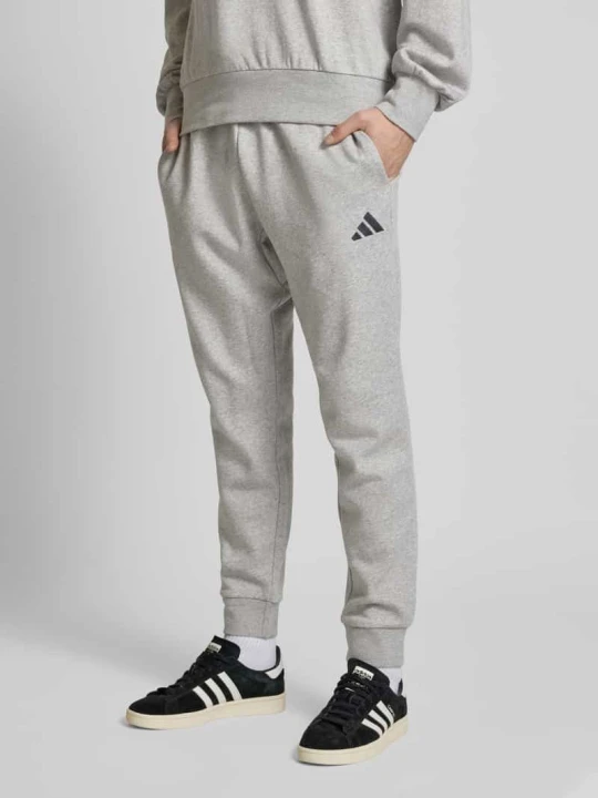 Zdjęcie produktu Spodnie dresowe o kroju relaxed fit z wyhaftowanym logo Adidas Jasnoszary