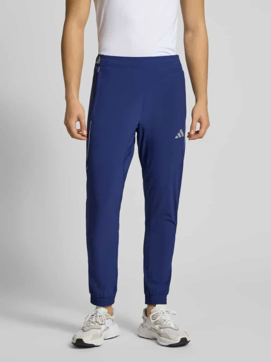 Zdjęcie produktu Spodnie dresowe o kroju slim fit z nadrukiem z logo model ‘Tech’ Adidas Ciemnoniebieski