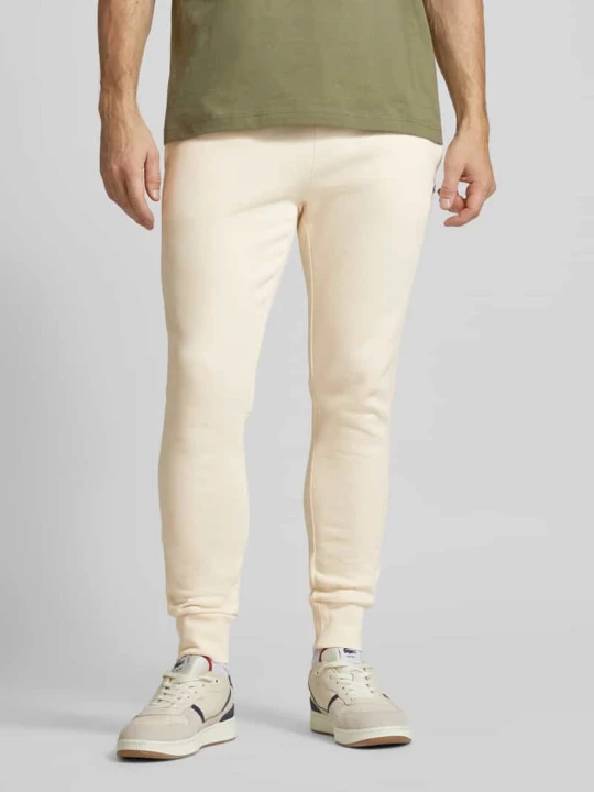 Zdjęcie produktu Spodnie dresowe o kroju slim fit z naszywką z logo Lacoste Złamany biały