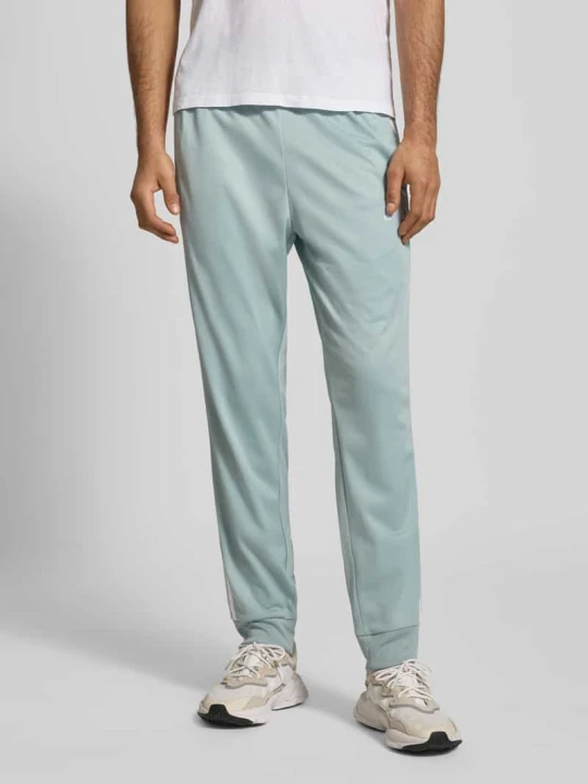 Zdjęcie produktu Spodnie dresowe w kroju slim fit z haftowanym logo Adidas Miętowy