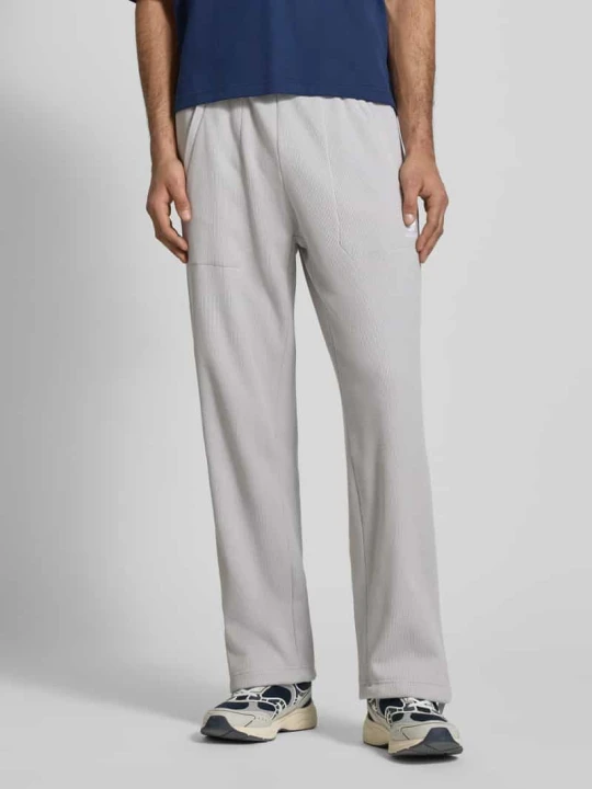 Zdjęcie produktu Spodnie dresowe o kroju straight fit z fakturowanym wzorem Model „Essentials” adidas Originals Jasnoszary