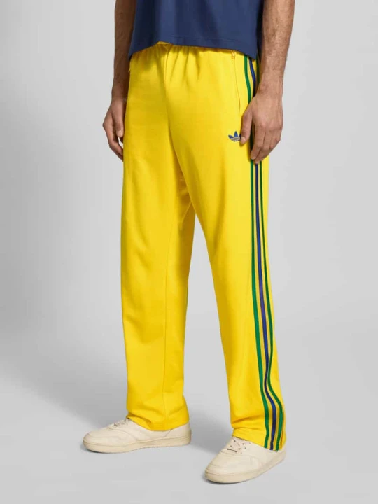 Zdjęcie produktu Spodnie dresowe o kroju regular fit z Wyhaftowane logo Model 'Firebird' adidas Originals Żółty