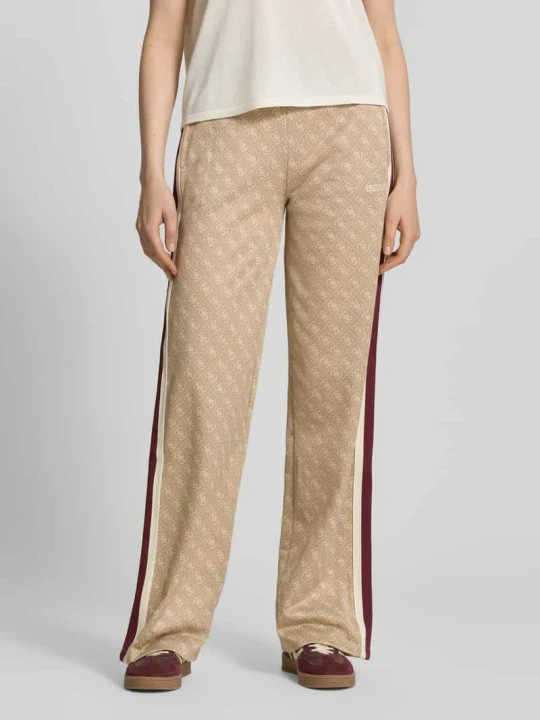 Zdjęcie produktu Spodnie dresowe o kroju wide fit z nadrukiem z logo na całej powierzchni model 'Jacquard' Guess Camel