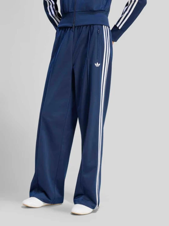 Zdjęcie produktu Spodnie dresowe o luźnym kroju z wyhaftowanym logo model 'FIREBIRD' adidas Originals Ciemnoniebieski