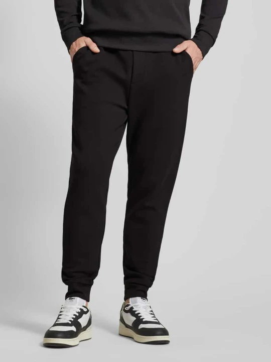 Zdjęcie produktu Spodnie dresowe męskie JOOP! Collection;Mieszanka bawełny z dodatkiem streczu;Krój loose fit;Model ‘Stelios’;Elastyczny pas z tunelem;Zaznaczony rozporek;Długoś Czarny