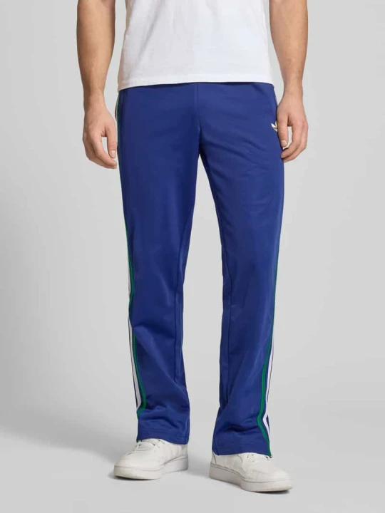 Zdjęcie produktu Spodnie dresowe w kroju regular fit z wielokolorowymi kontrastowymi lampasami model 'FIREBIRD TP' adidas Originals Ciemnoniebieski