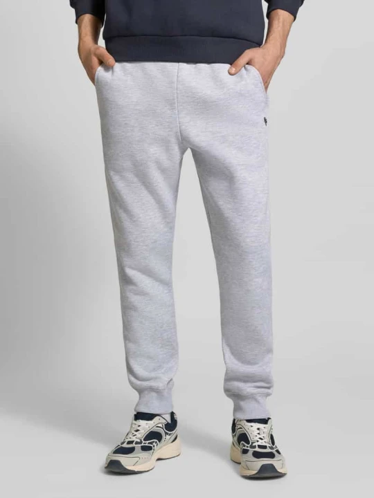 Zdjęcie produktu Spodnie dresowe w kroju slim fit z haftowanym logo REVIEW Jasnoszary melanż